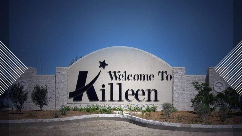 Welcome to Killeen, Texas sign with stone wall backdrop, landscaped greenery, and clear blue sky.